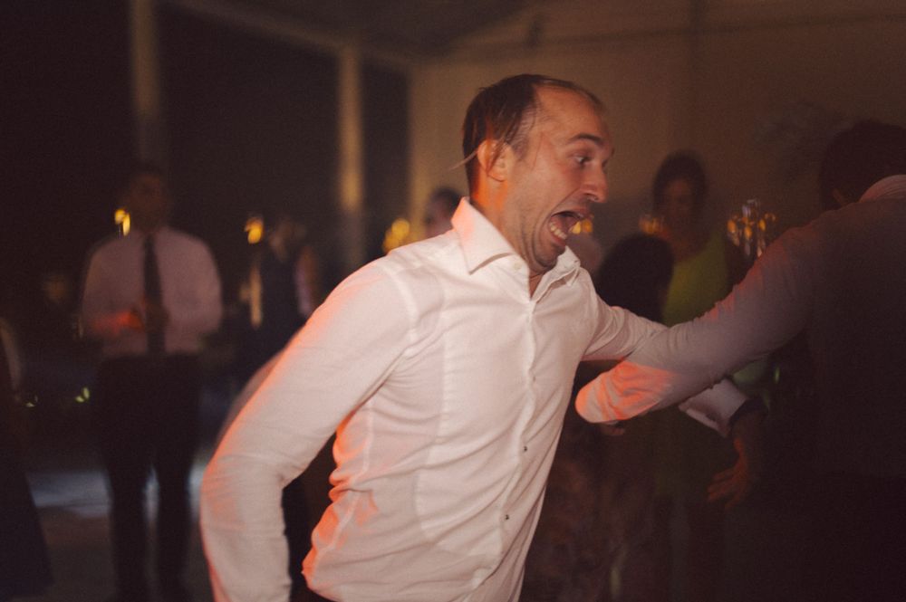 Person in white shirt dancing energetically at a party.