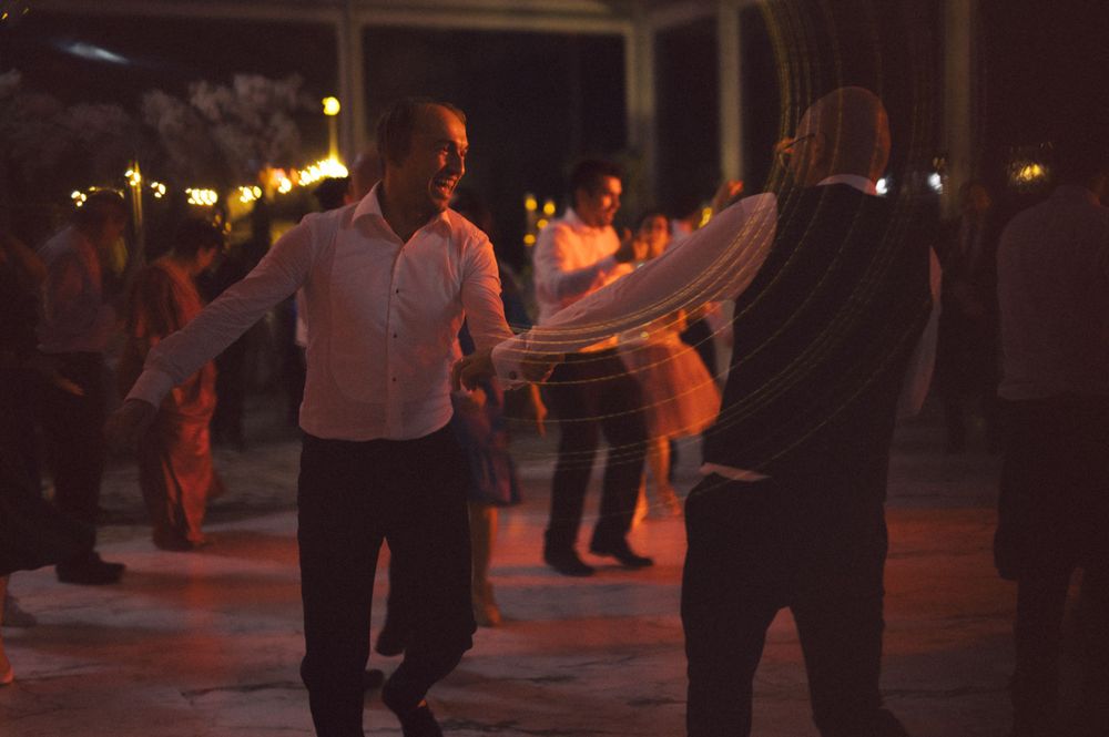 People dancing together on a dimly lit dance floor with warm lighting.