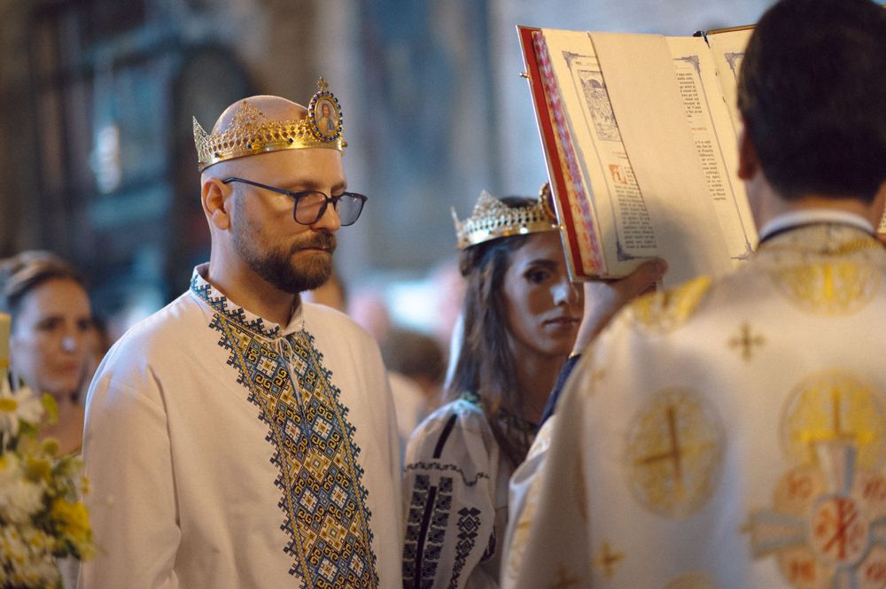 A traditional Orthodox wedding ceremony with participants wearing ornate crowns and embroidered clothing.