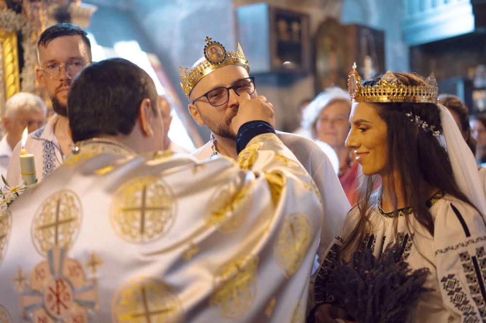 An Orthodox wedding ceremony with ornate crowns and traditional religious vestments.