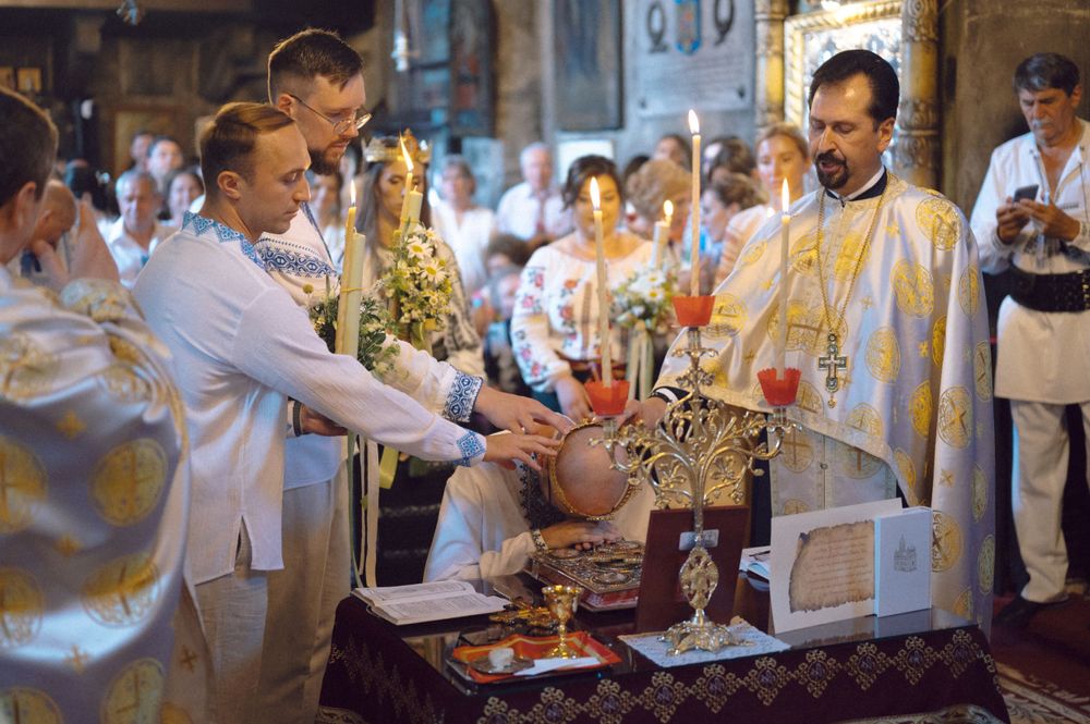 Clergy members perform a religious ritual with golden ceremonial objects during an Orthodox service.