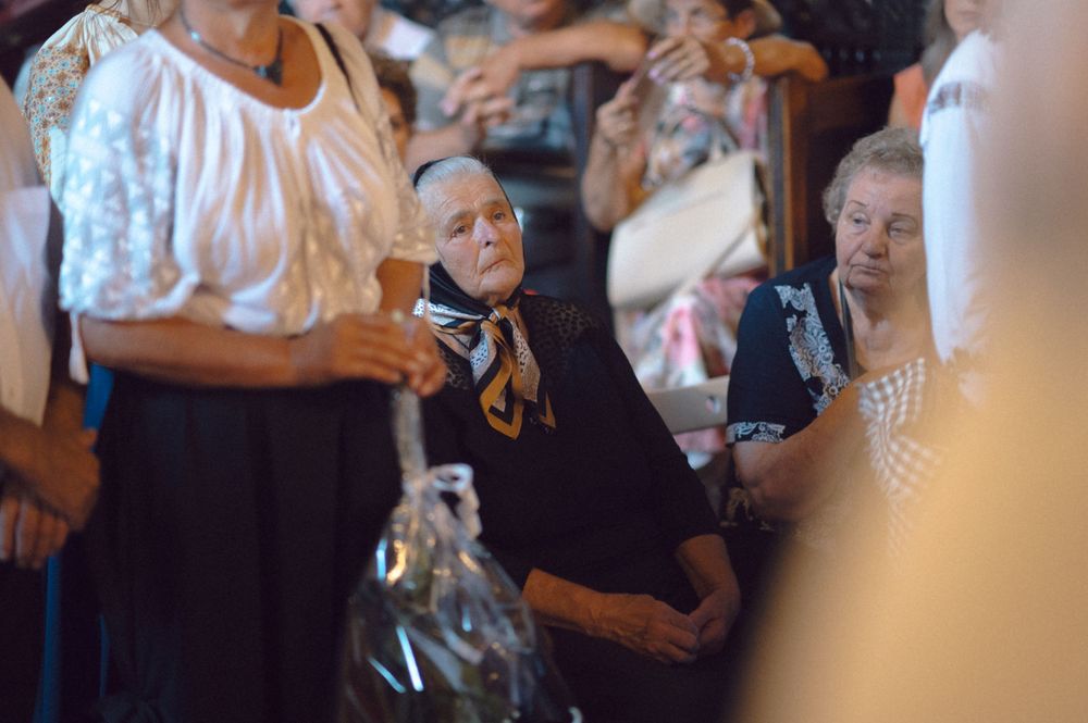 Attendees gather in formal attire during an indoor ceremony or event.