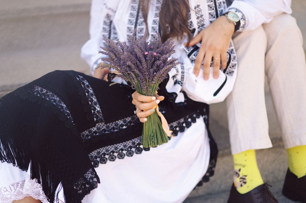 Detail shot of Romanian folk costumes with lavender bouquet and embroidered details.