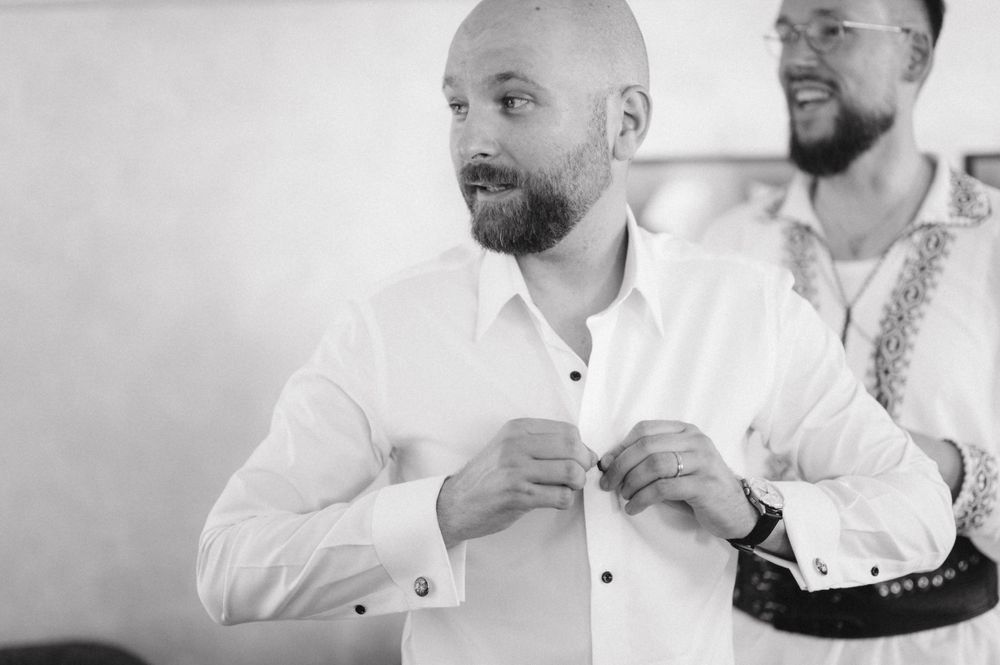 Black and white portrait of men in formal attire preparing for an event.
