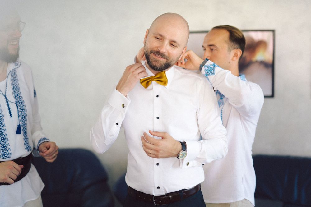 Final adjustments being made to yellow bowtie during formal dressing.