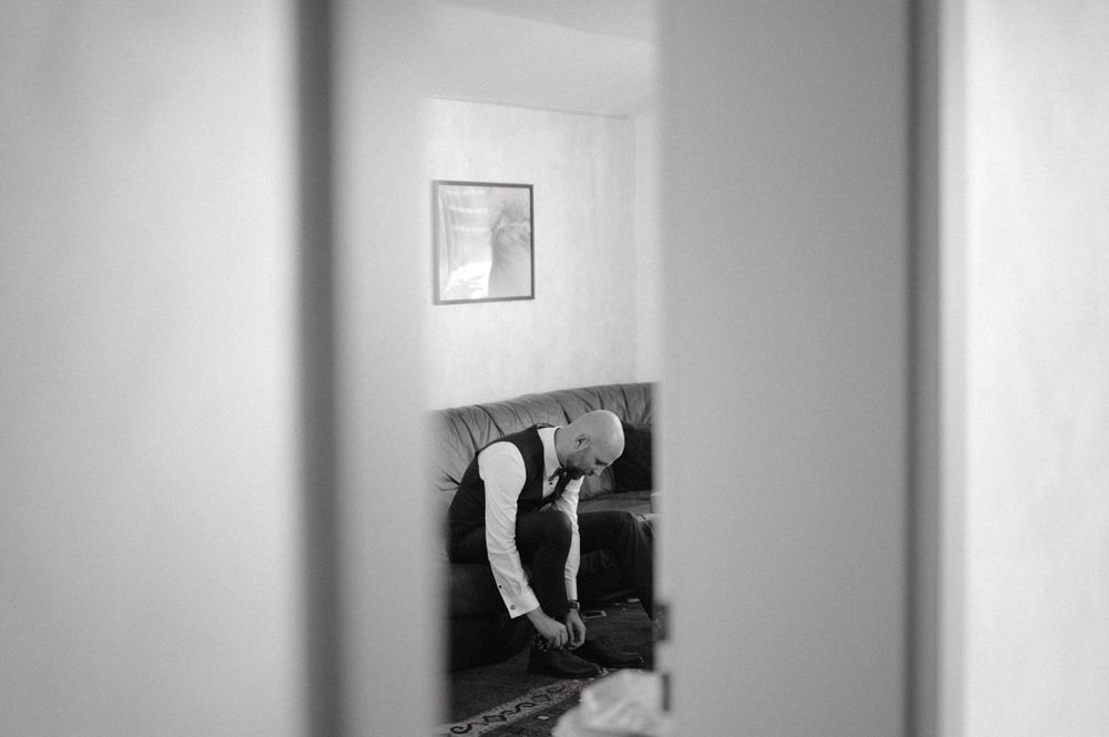 Black and white image through doorway showing formal preparation.