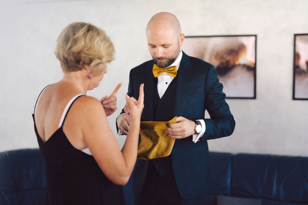 Two people in formal attire discussing during event preparation.