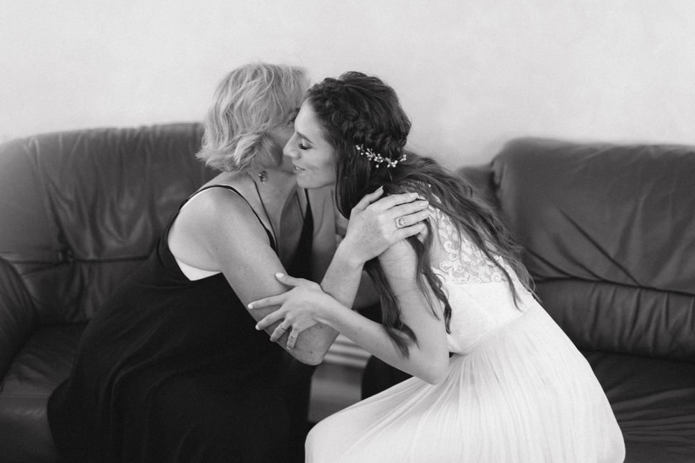 Black and white photo of intimate emotional moment between two women on couch.
