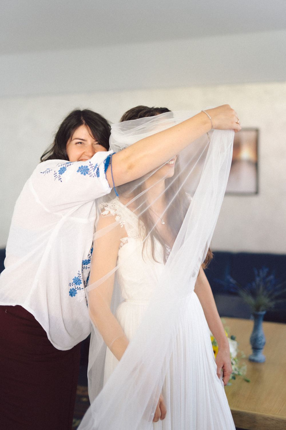 Final adjustments being made to a wedding veil in an indoor setting.
