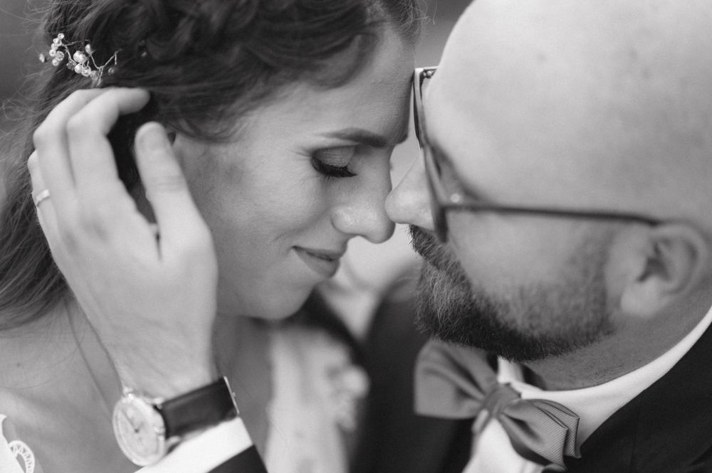 Romantic black and white close-up of a tender moment between newlyweds.