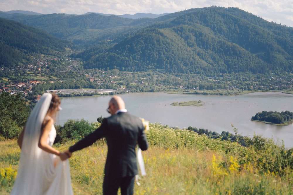 Couple admiring stunning mountain lake view from elevated vantage point.