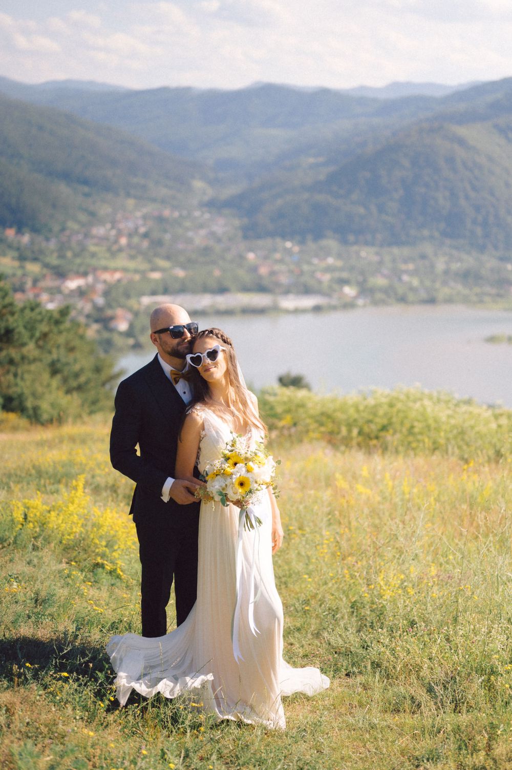 Romantic wedding portrait in front of scenic mountain lake landscape.