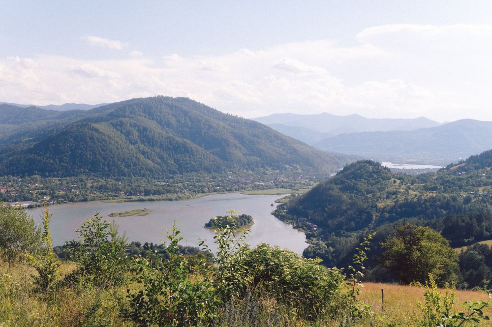 Scenic mountain landscape with winding river and forested hills.