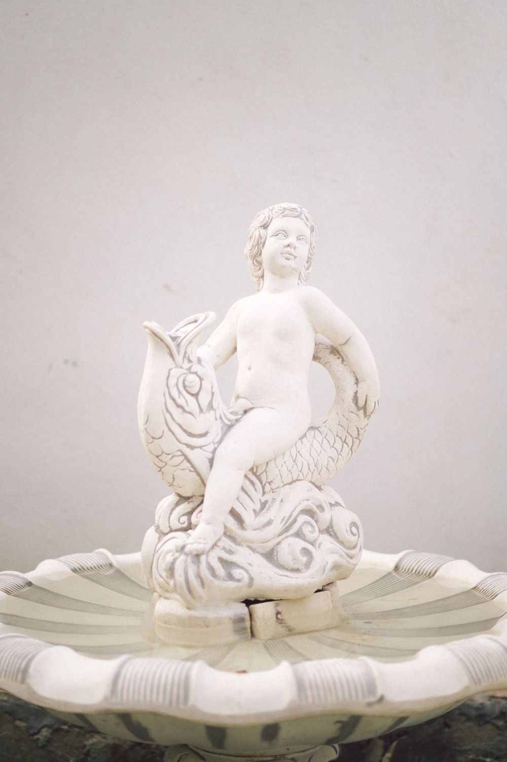 White marble cherub fountain statue with decorative water features.