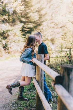 A romantic countryside scene with denim jacket and boots against a wooden fence on a sunny afternoon.