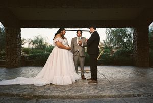 Wedding ceremony taking place in a rustic outdoor setting.