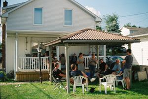 White house exterior with patio furniture and gathering spaces.