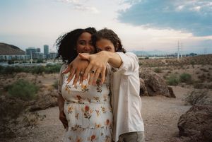 A loving outdoor photoshoot in a desert landscape with blue skies.