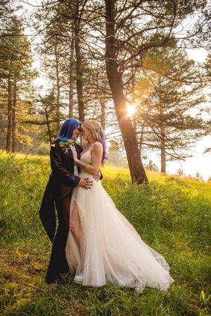 Couple embraces in sunlit forest setting during golden hour wedding photoshoot.