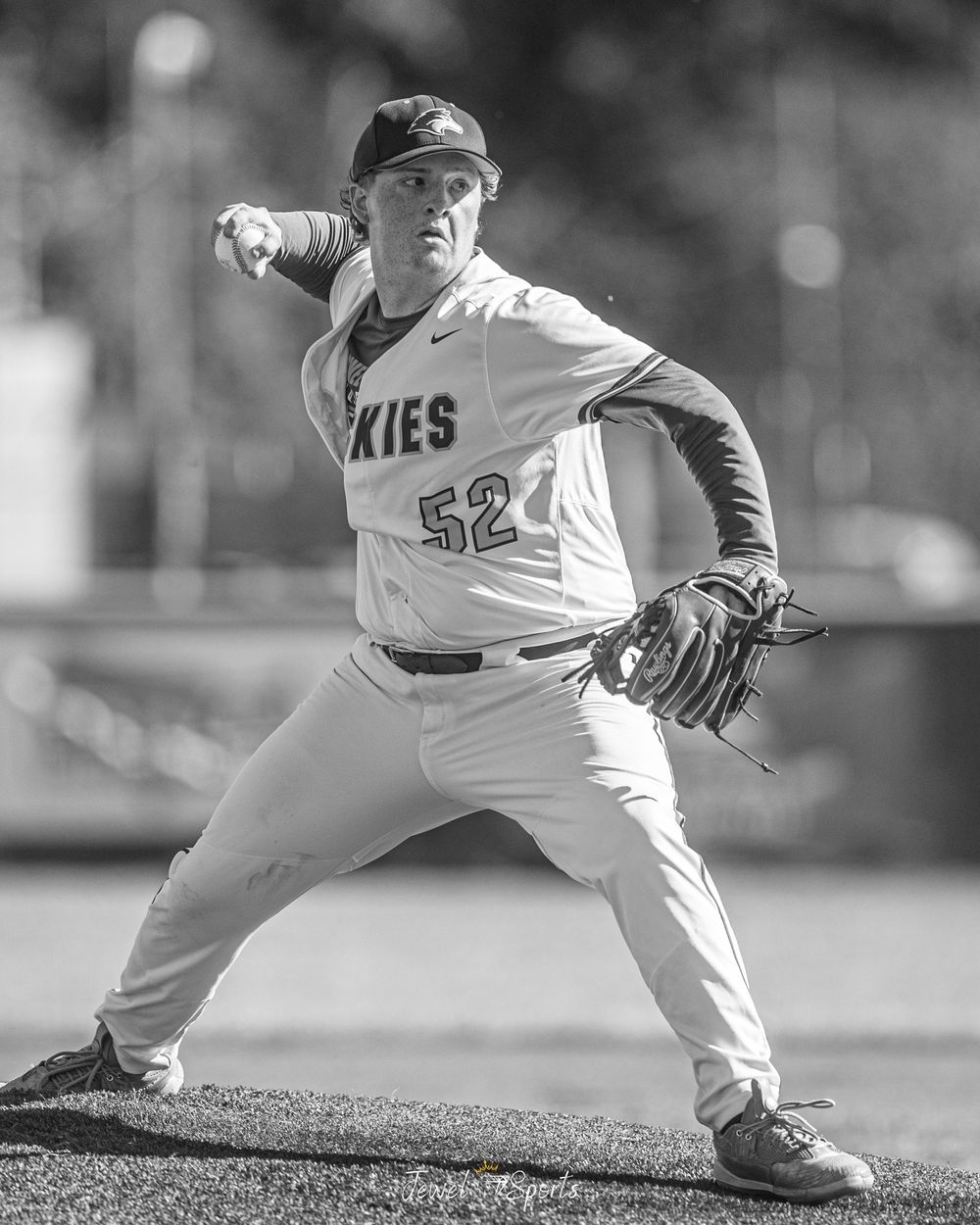 Black and white photo of baseball pitcher number 52 in mid-windup on the mound.