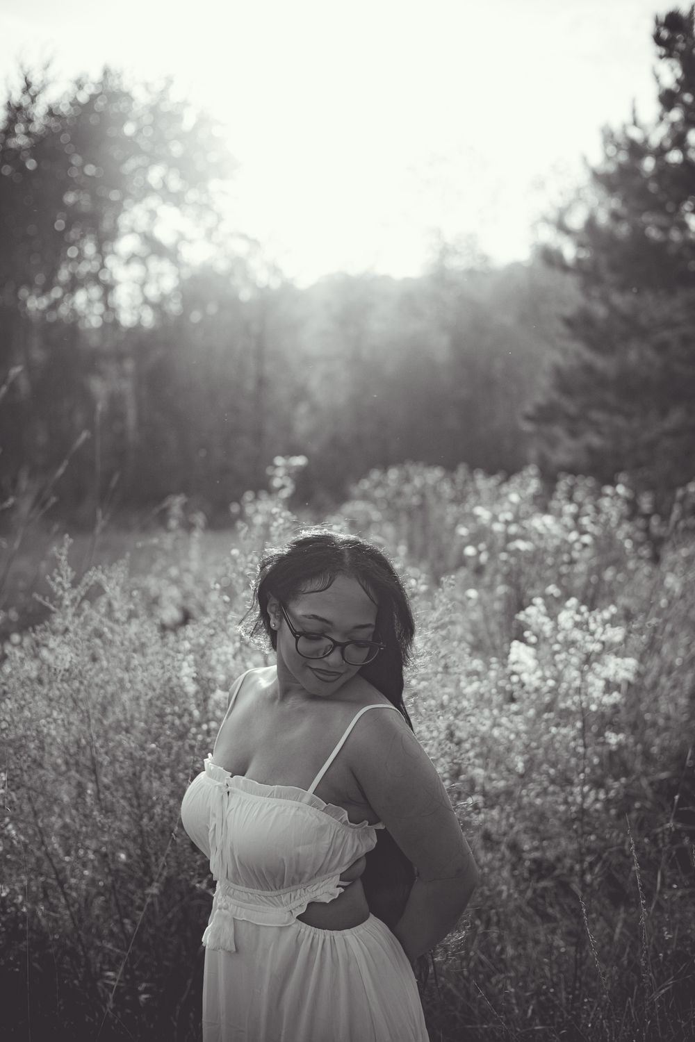 Black and white portrait in a wildflower field with natural backlighting.