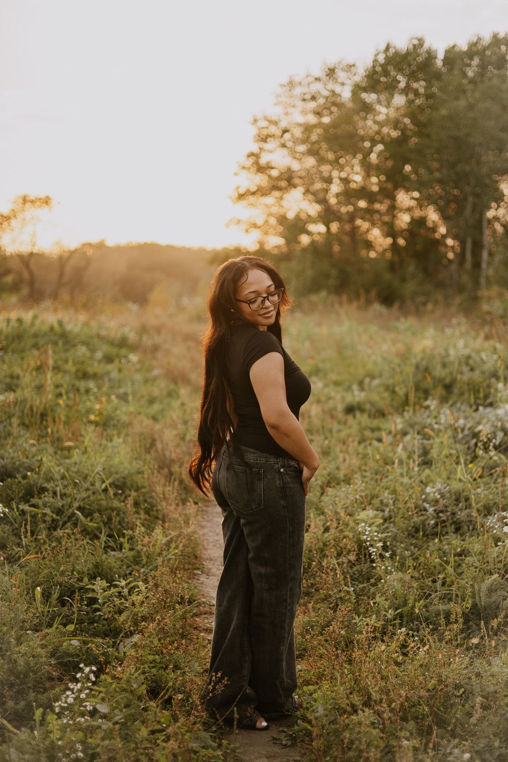 Playful outdoor portrait session in black attire among summer wildflowers.