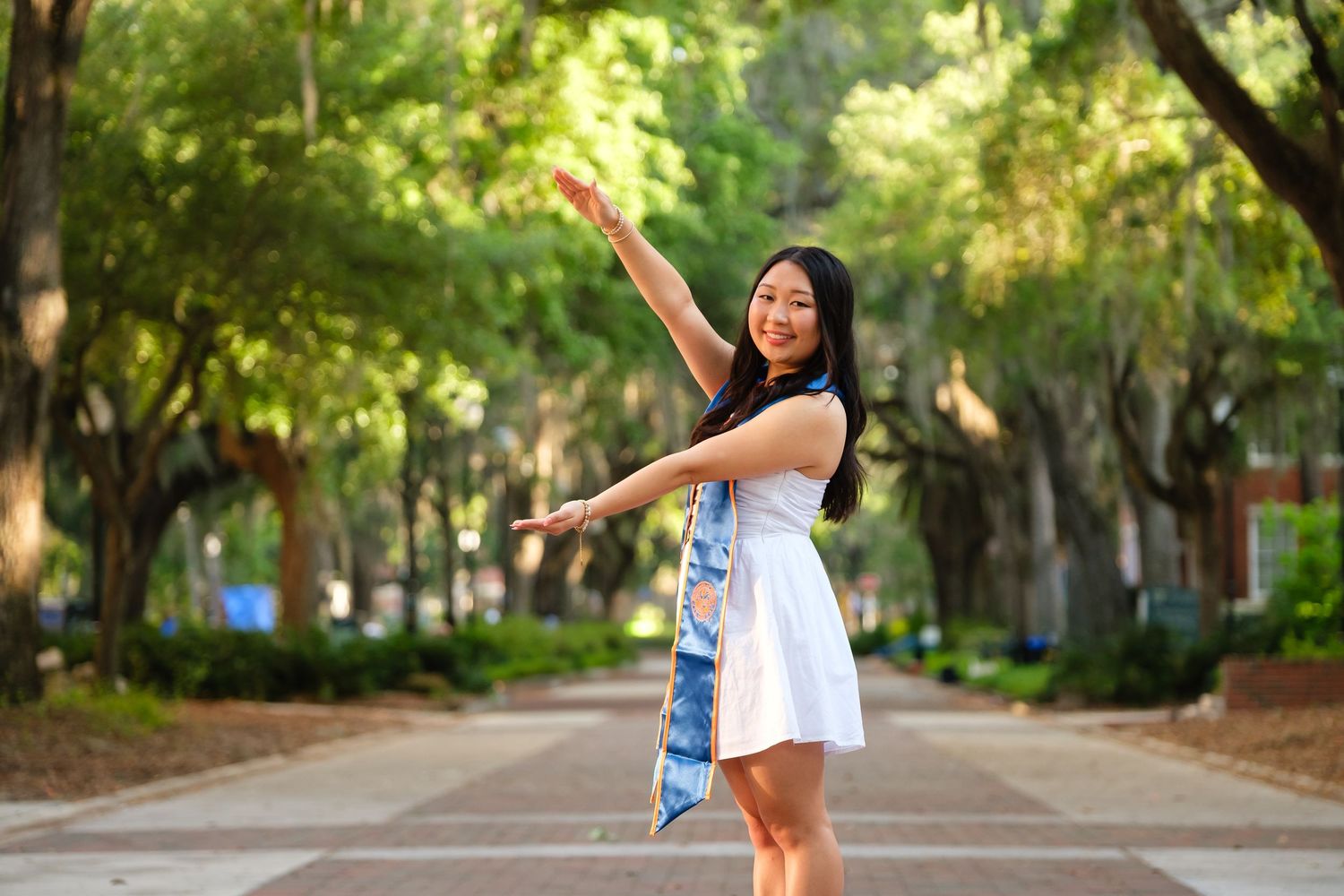 UF graduate poses with the Bull Gator statue at the University of Florida.