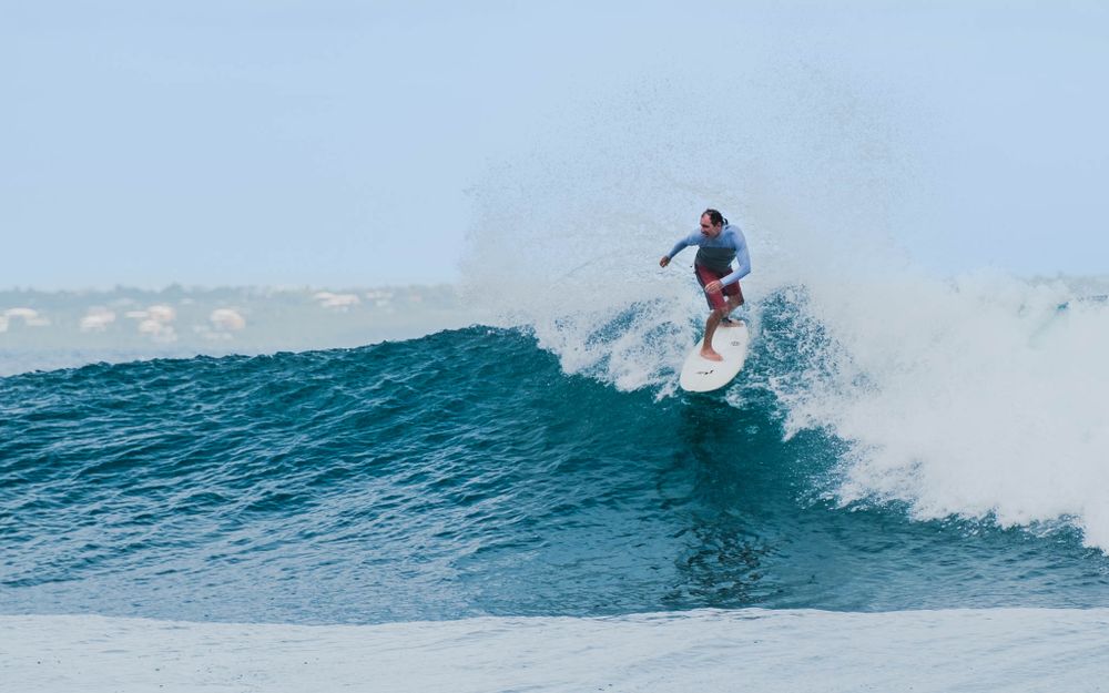 Skilled surfer performs an aerial trick off the lip of a powerful ocean wave.