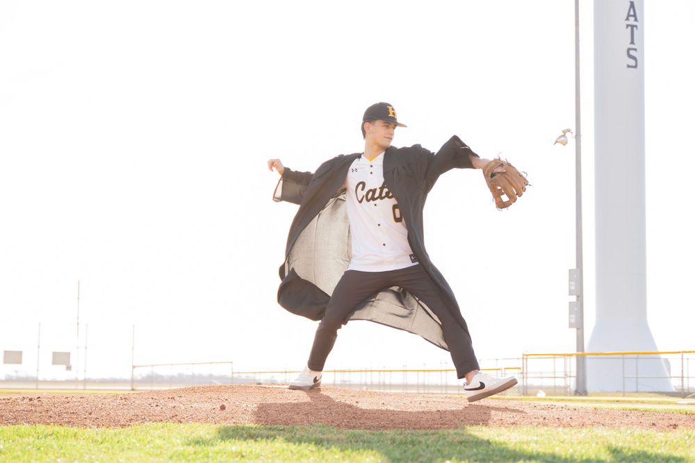 Baseball player in a Cal jersey winds up for a pitch on a sunlit field.