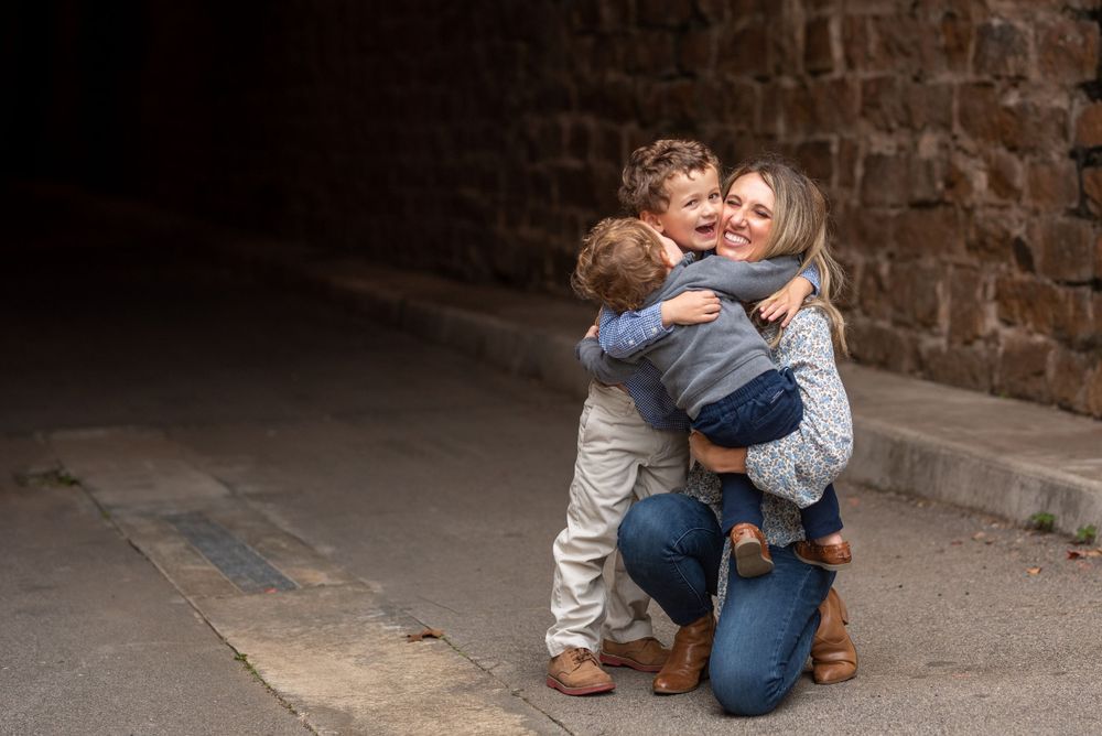 Tender embraces captured against rustic brick wall background.