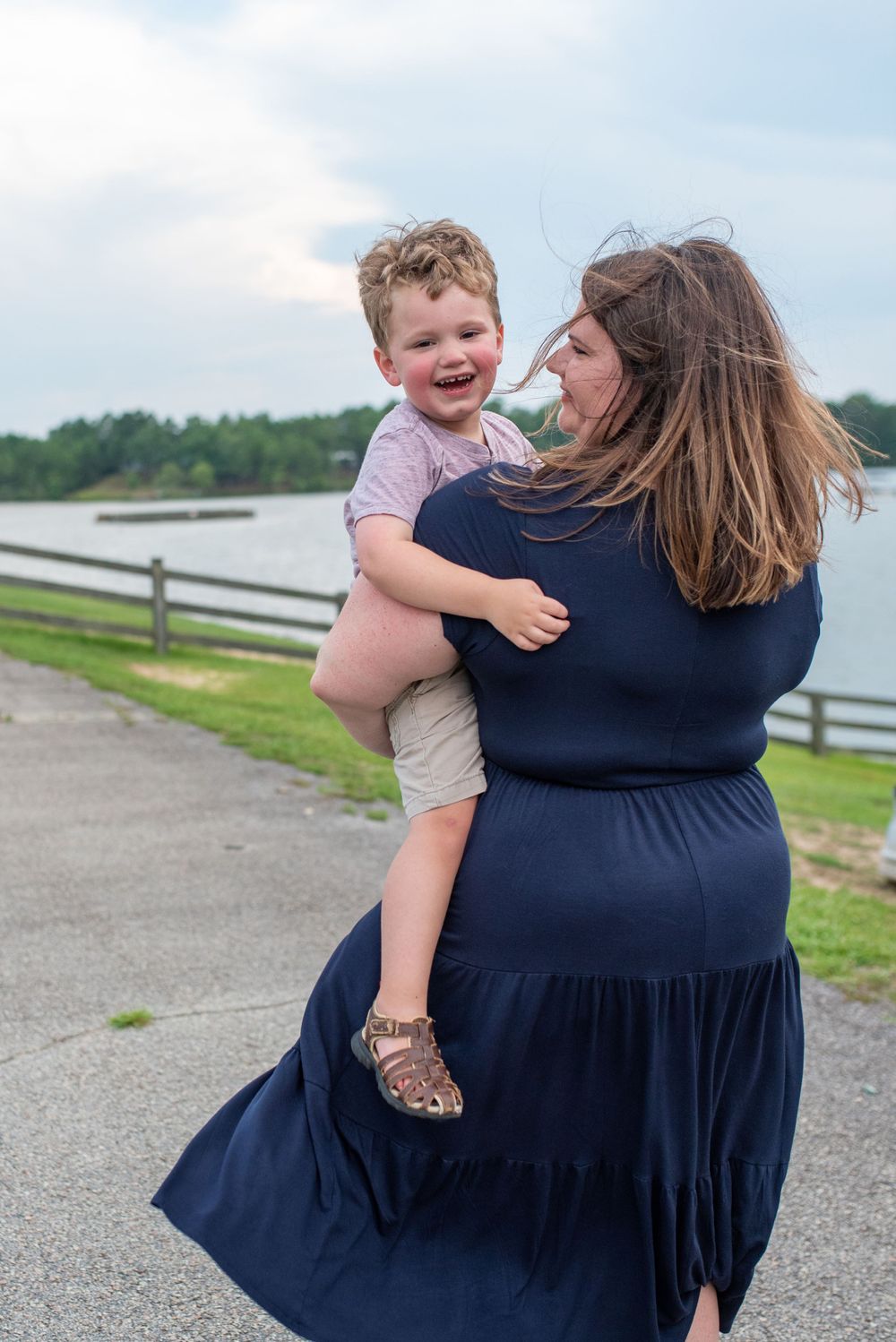 Candid moments of joy and laughter shared between parent and child by the waterfront.