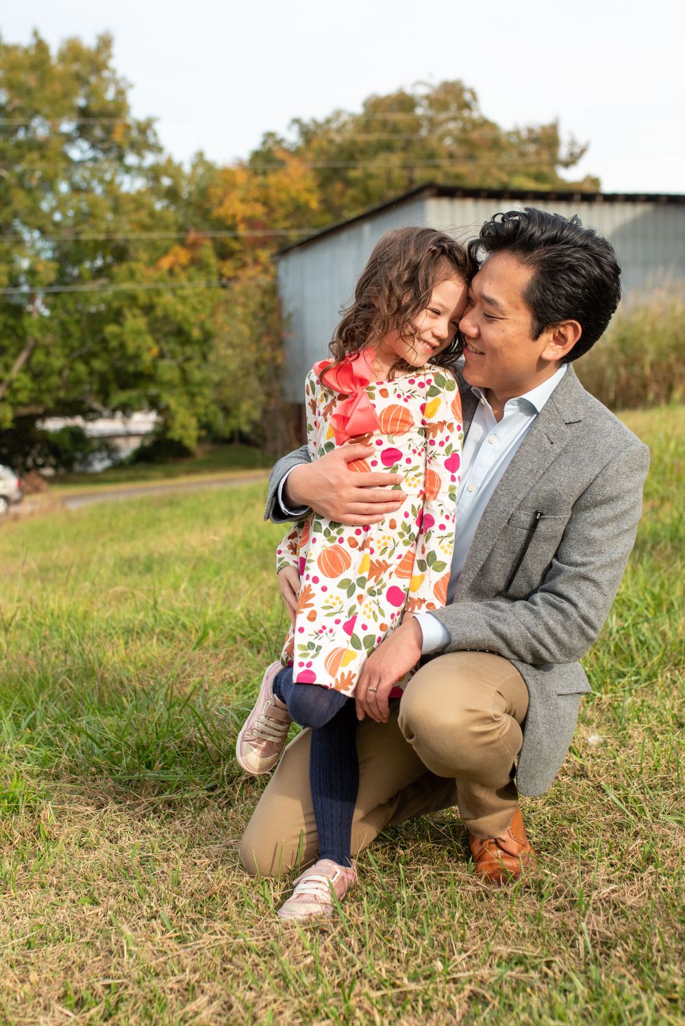 Tender moments shared between parent and child on grassy hillside.