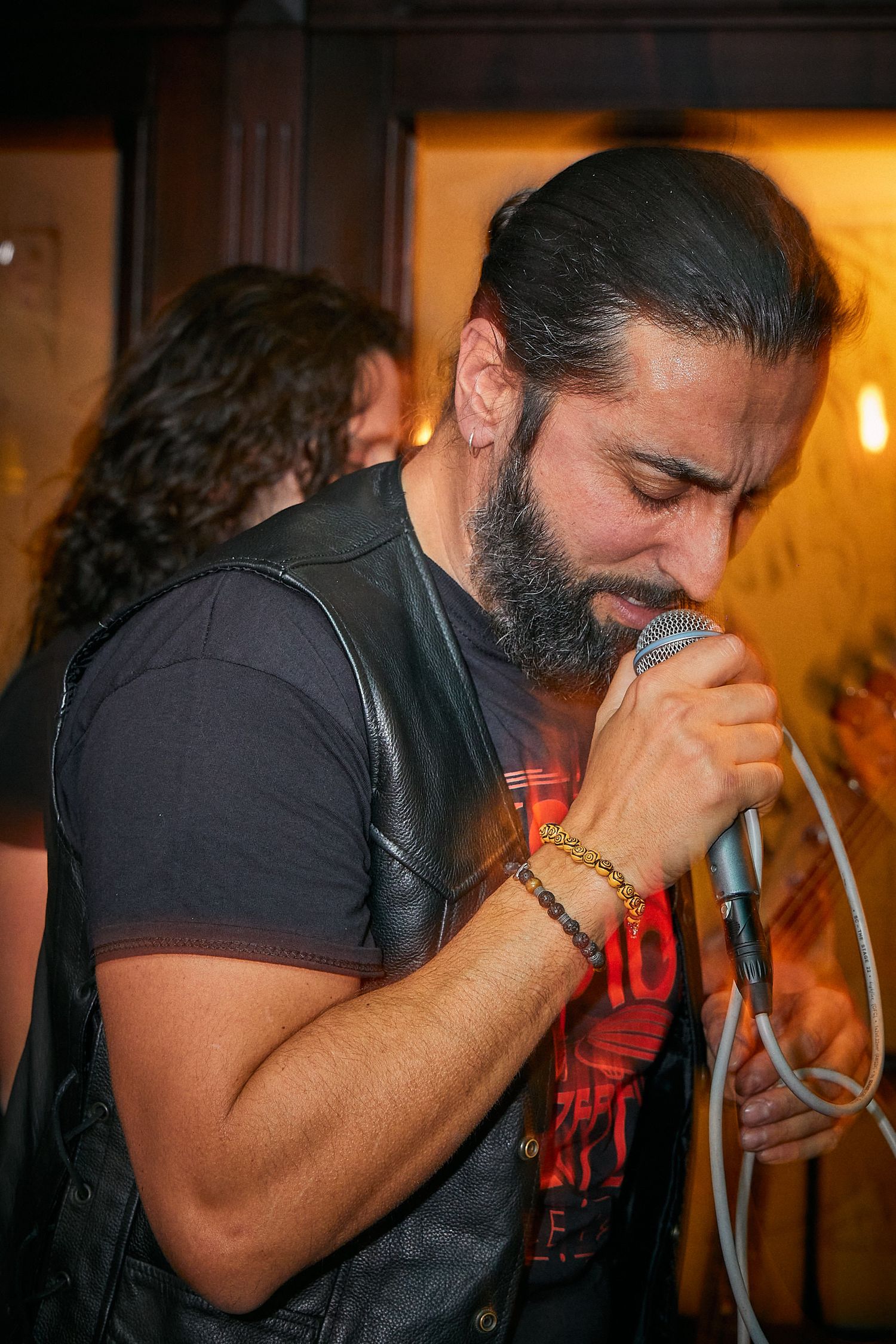 Performer singing passionately into microphone during live music performance.