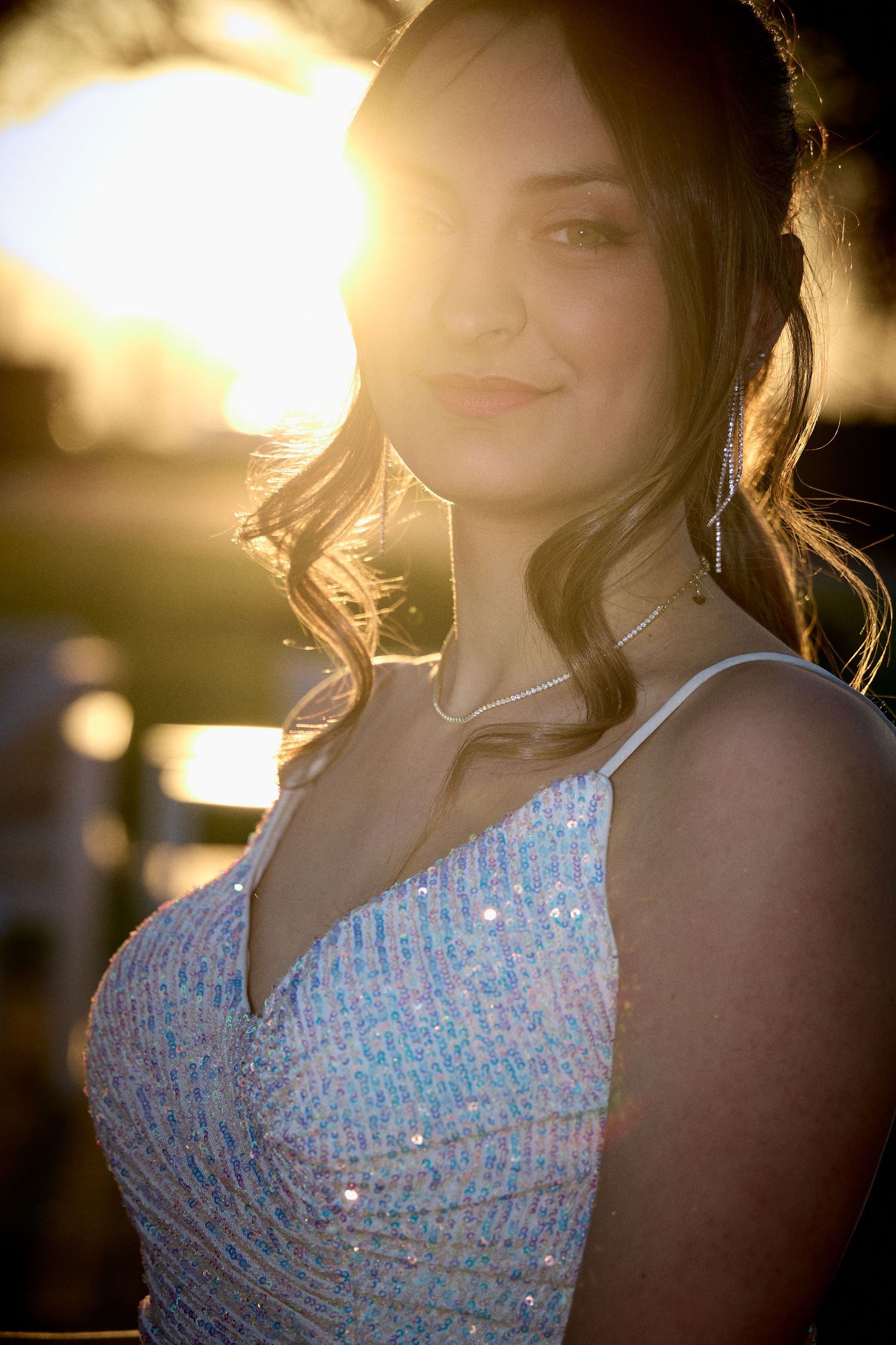 Portrait of person in sparkly formal dress with golden sunset lighting.