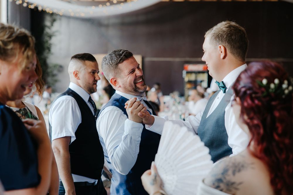 Guests enjoying a celebration in an indoor venue with elegant decor and lighting.