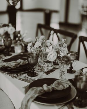 Black and white photo of an elegant wedding reception table with floral centerpieces.