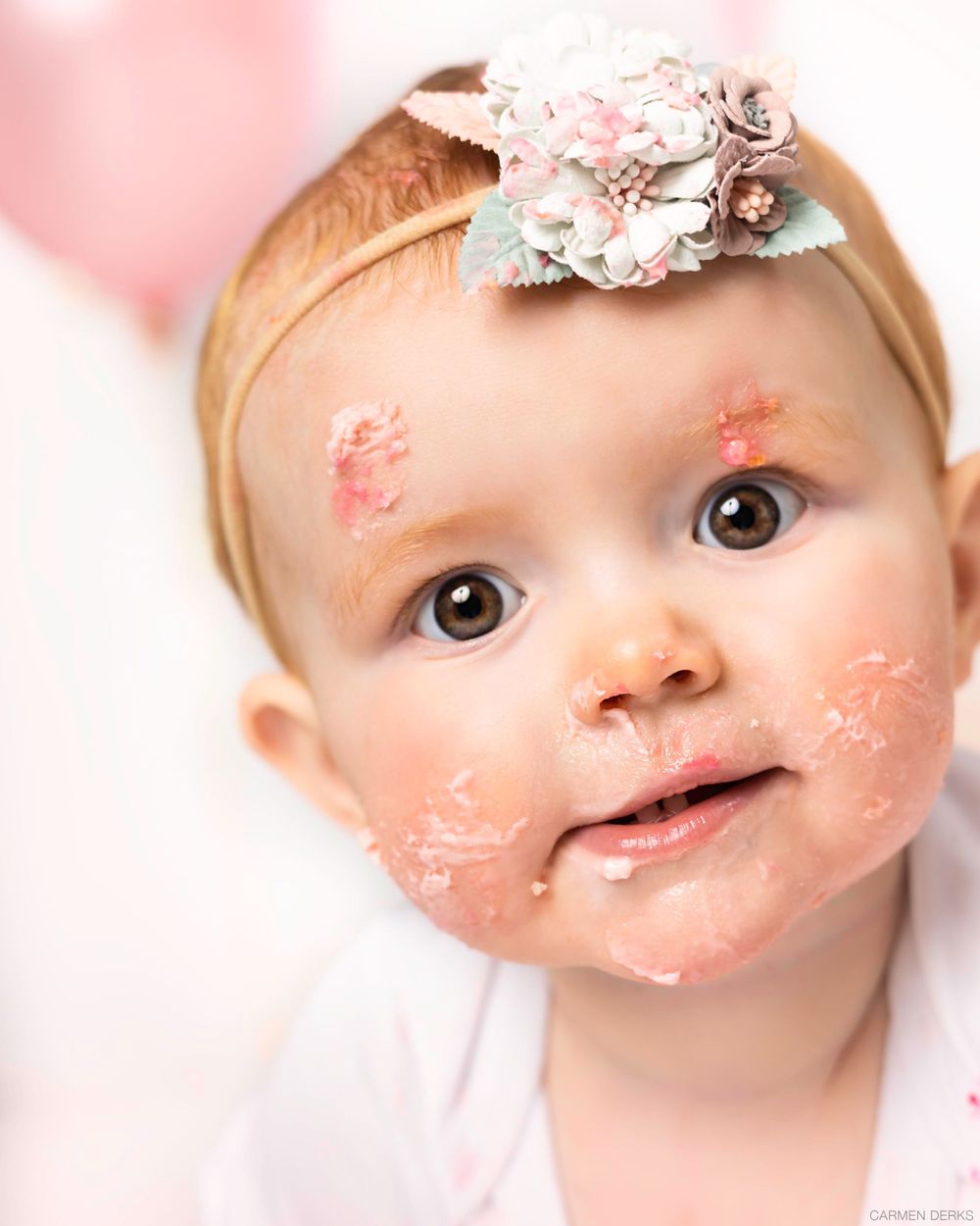cakesmash photoshoot 1 jaar 
met zacht roze kleuren en ballonnen, kindje heeft taart op haar gezicht. in studio in maas en waal