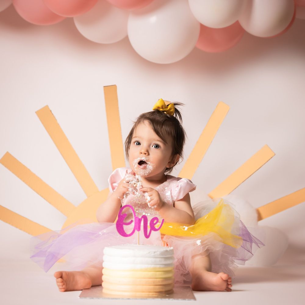 cakesmash photoshoot 1 jaar 
lichte kleuren met een zon op de achtergrond.