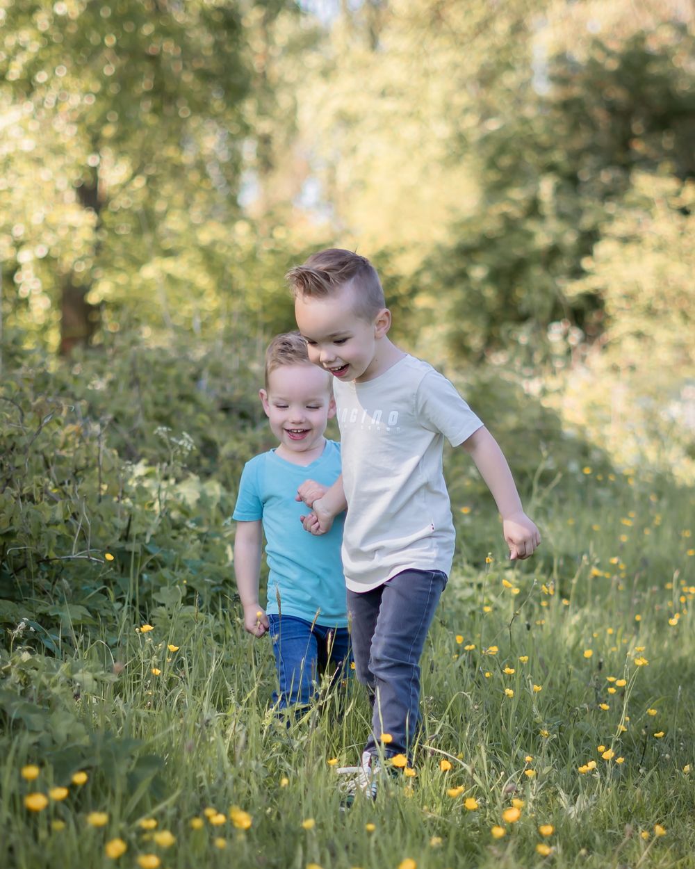 photoshoot ten behoeve van verjaardag. kindje staat in grasveld samen met grotere broer. fine art stijl. in Druten, west maas en waal