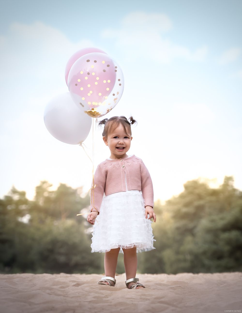 photoshoot ten behoeve van verjaardag. kindje staat in het zand houdt ballonnen vast. fine art stijl. gefotografeerd in west maas en waal