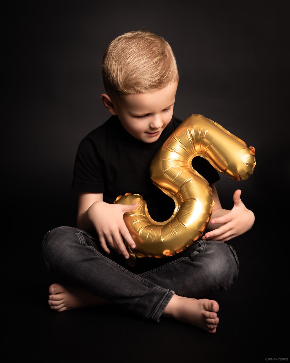 studio photoshoot ten behoeve van verjaardag. kindje zit op grond en houdt ballon vast.  gefotografeerd in West Maas en Waal.