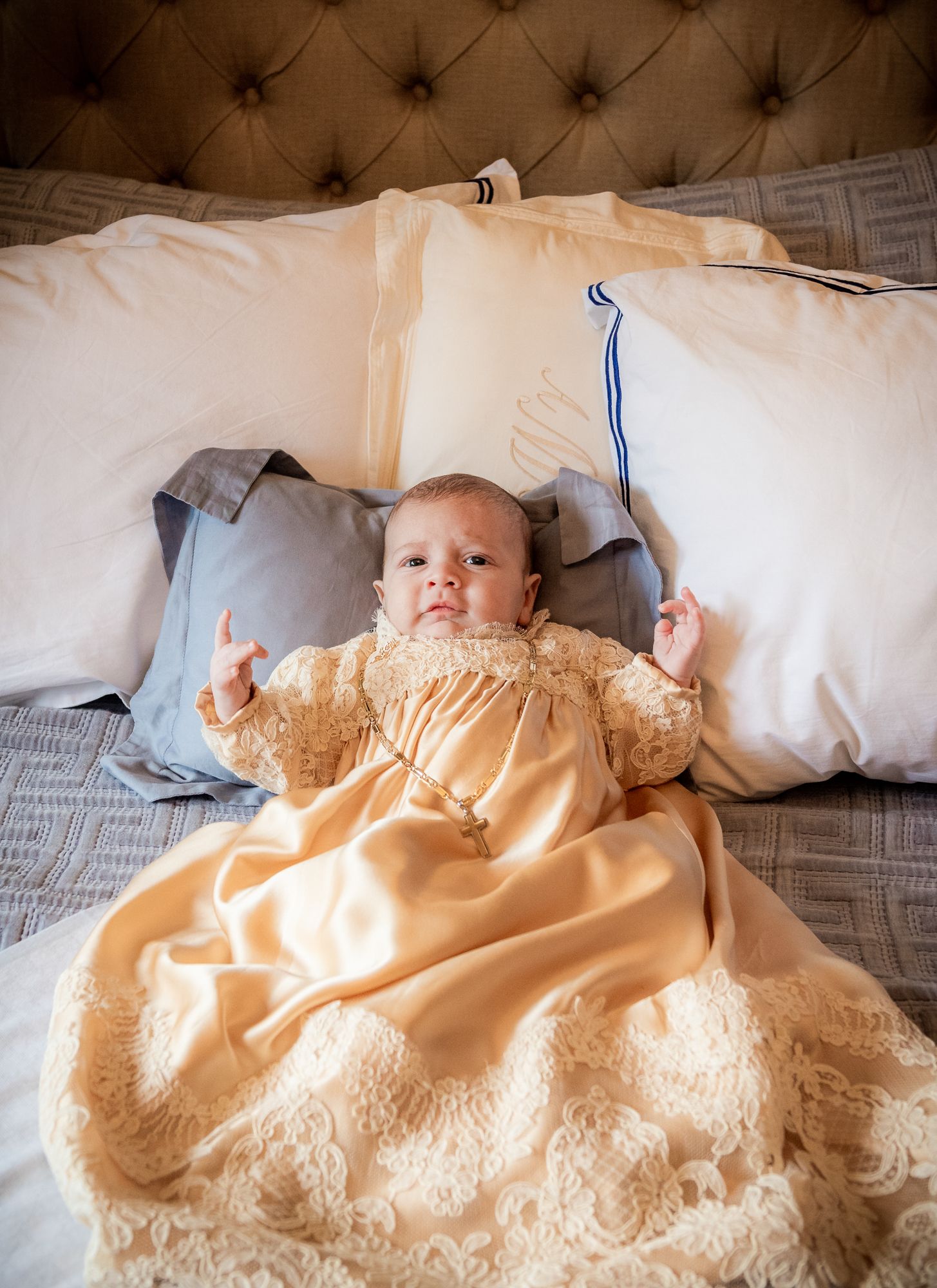 photography of the baptism event showing a baby boy in the baptism gown  and a cross