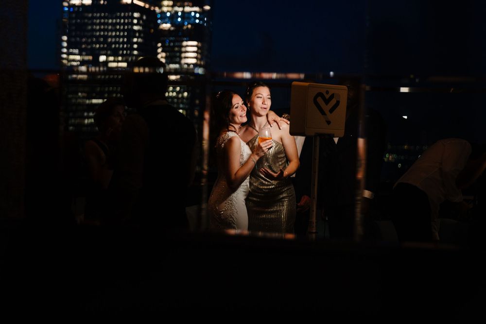 Romantic nighttime portrait through window with city lights in background.