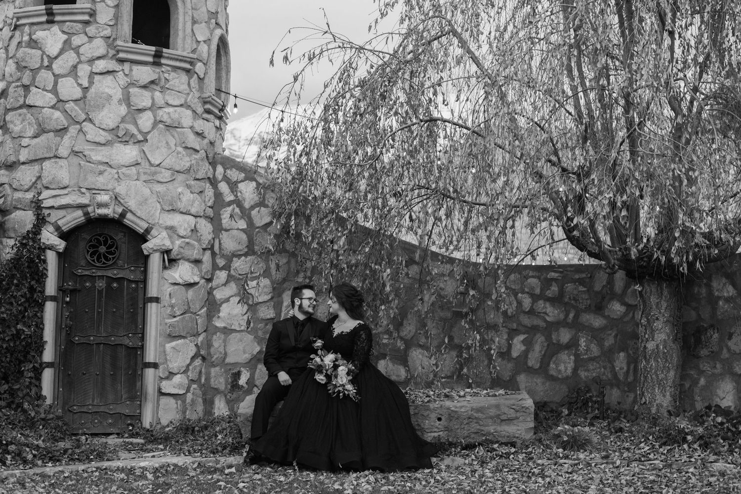 A series of black and white vintage photographs showing people in Victorian-era dress posing outside stone buildings.