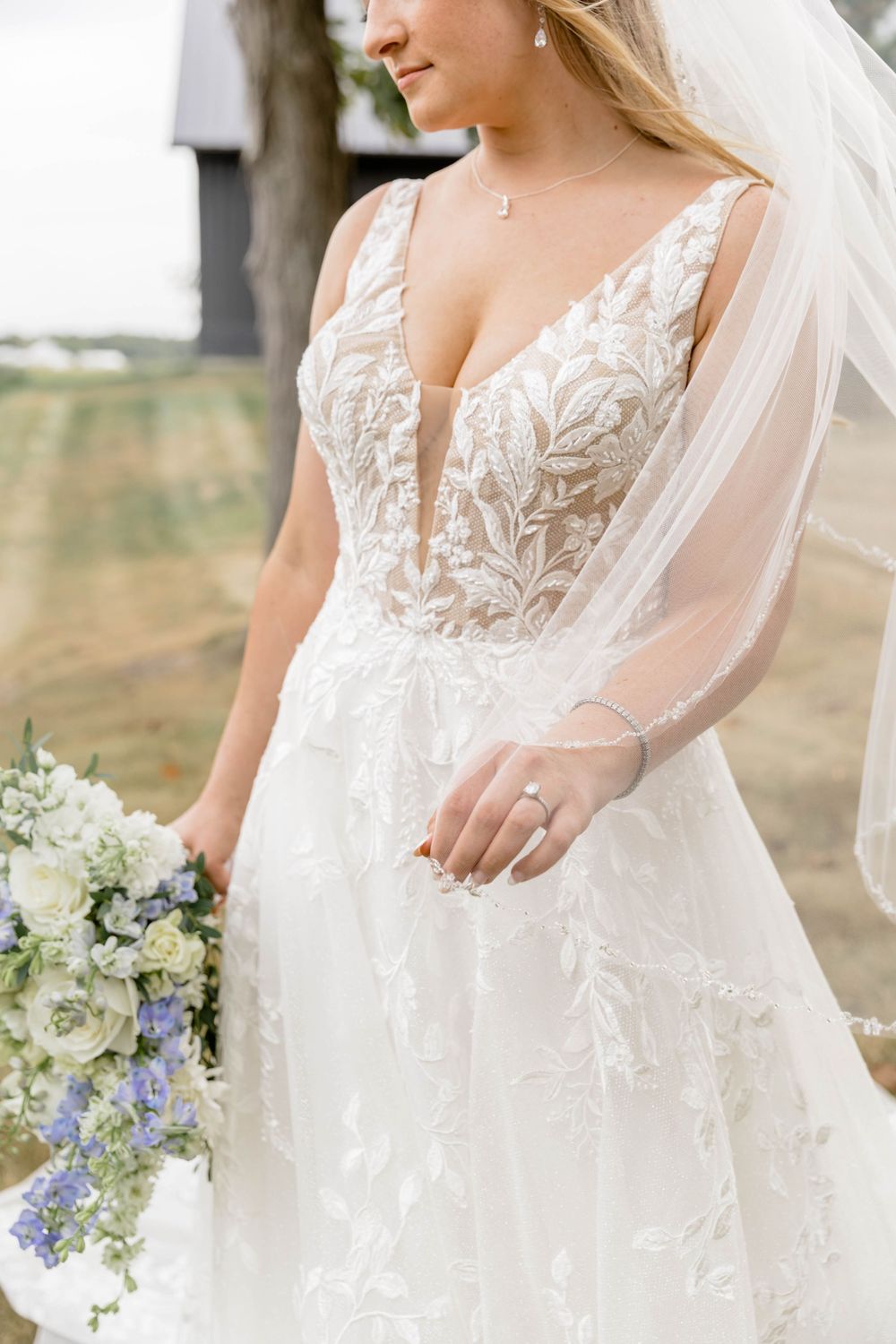 Close-up details of lace wedding dress with delicate embroidery and veil.