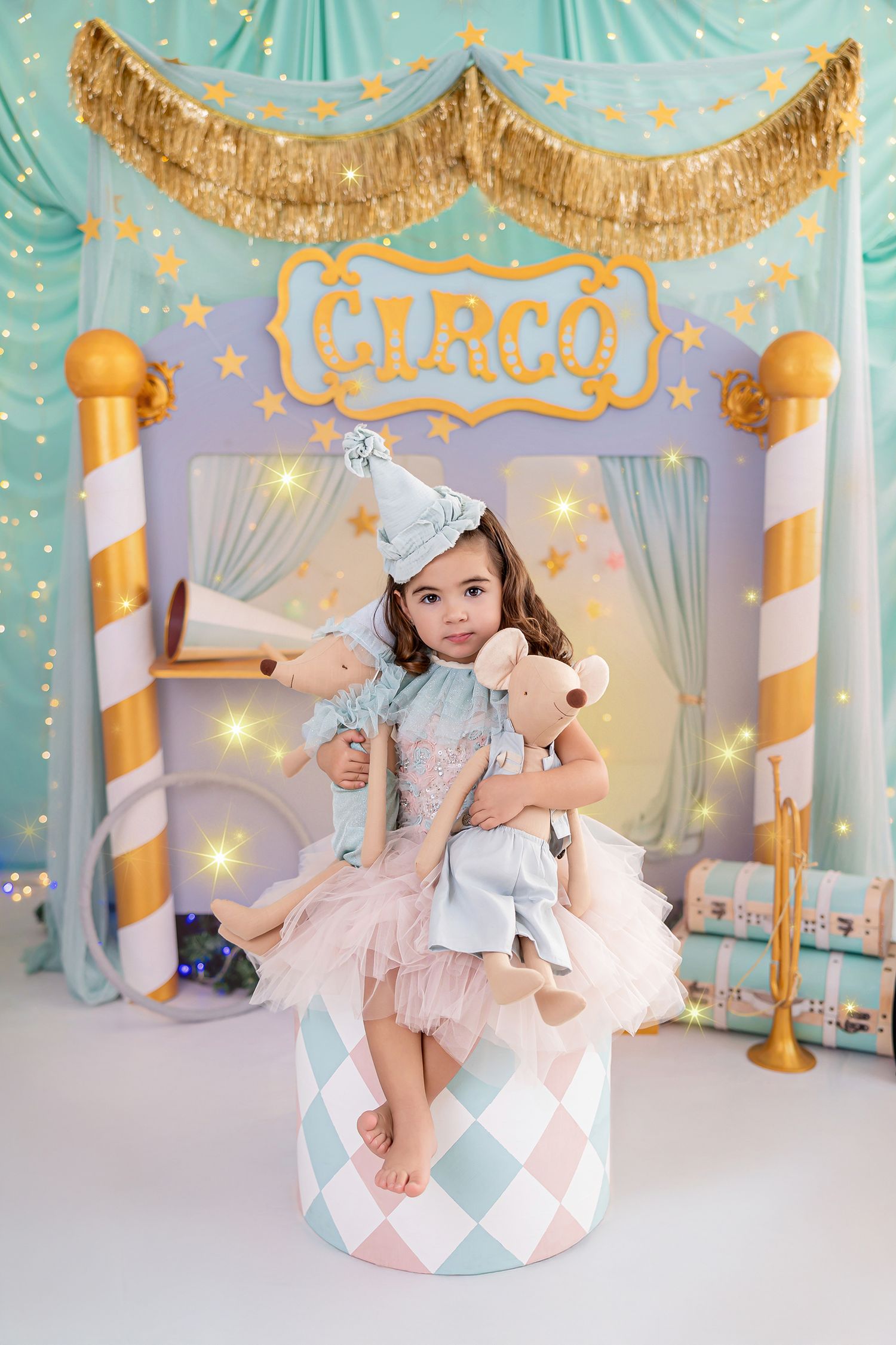 Fotografía infantil de niña con peluches en decorado de circo en tonos turquesa y dorado en el estudio de Rosi López Fotografía en Cuenca