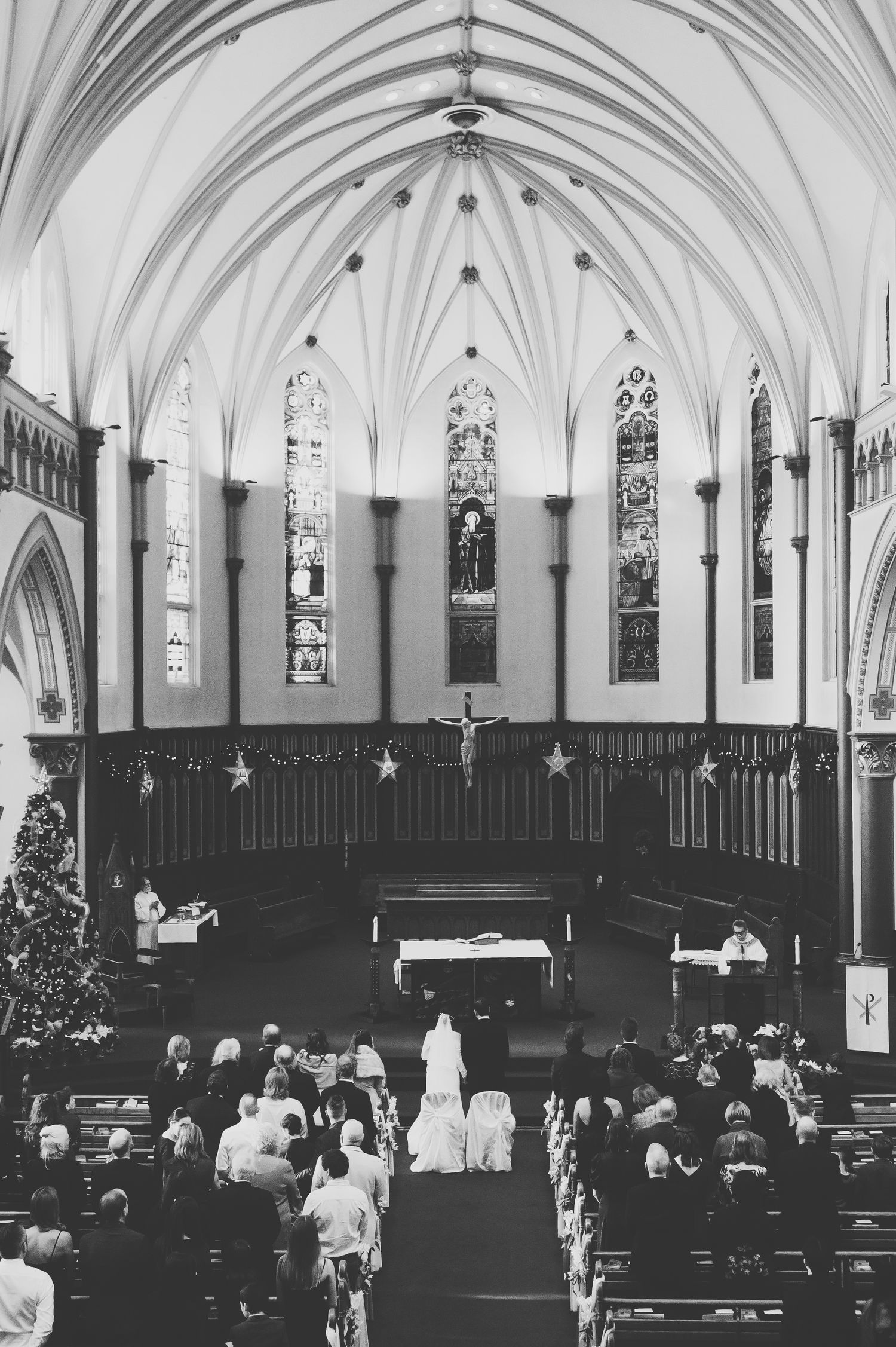 a bride walks down the aisle at her wedding mass ceremony at st andrew's cathedral in victoria, bc.