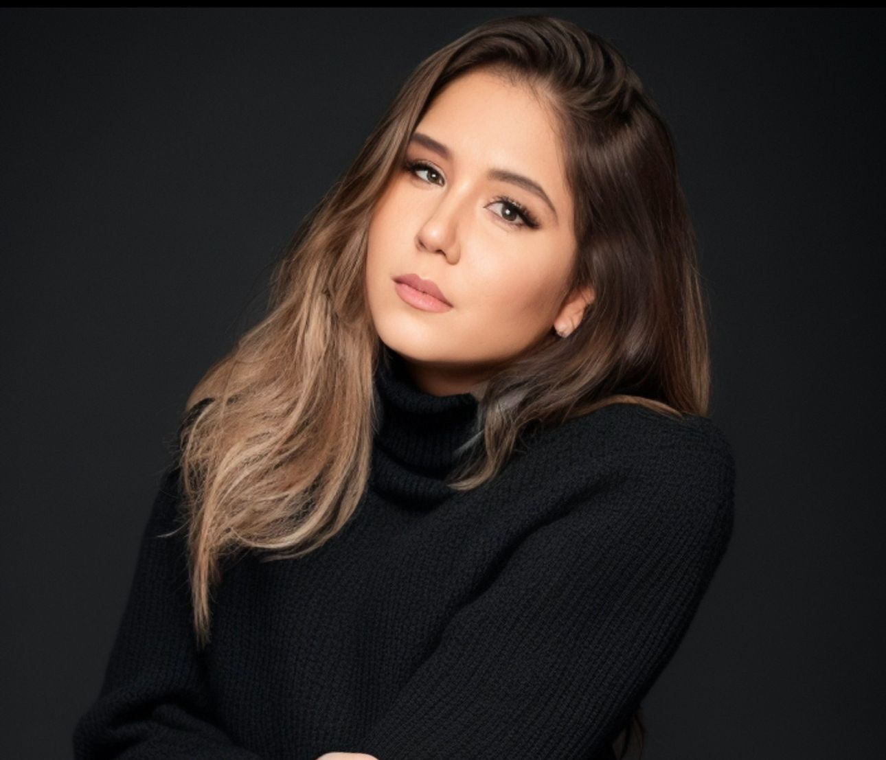 Studio portraits featuring moody lighting and a black turtleneck sweater.