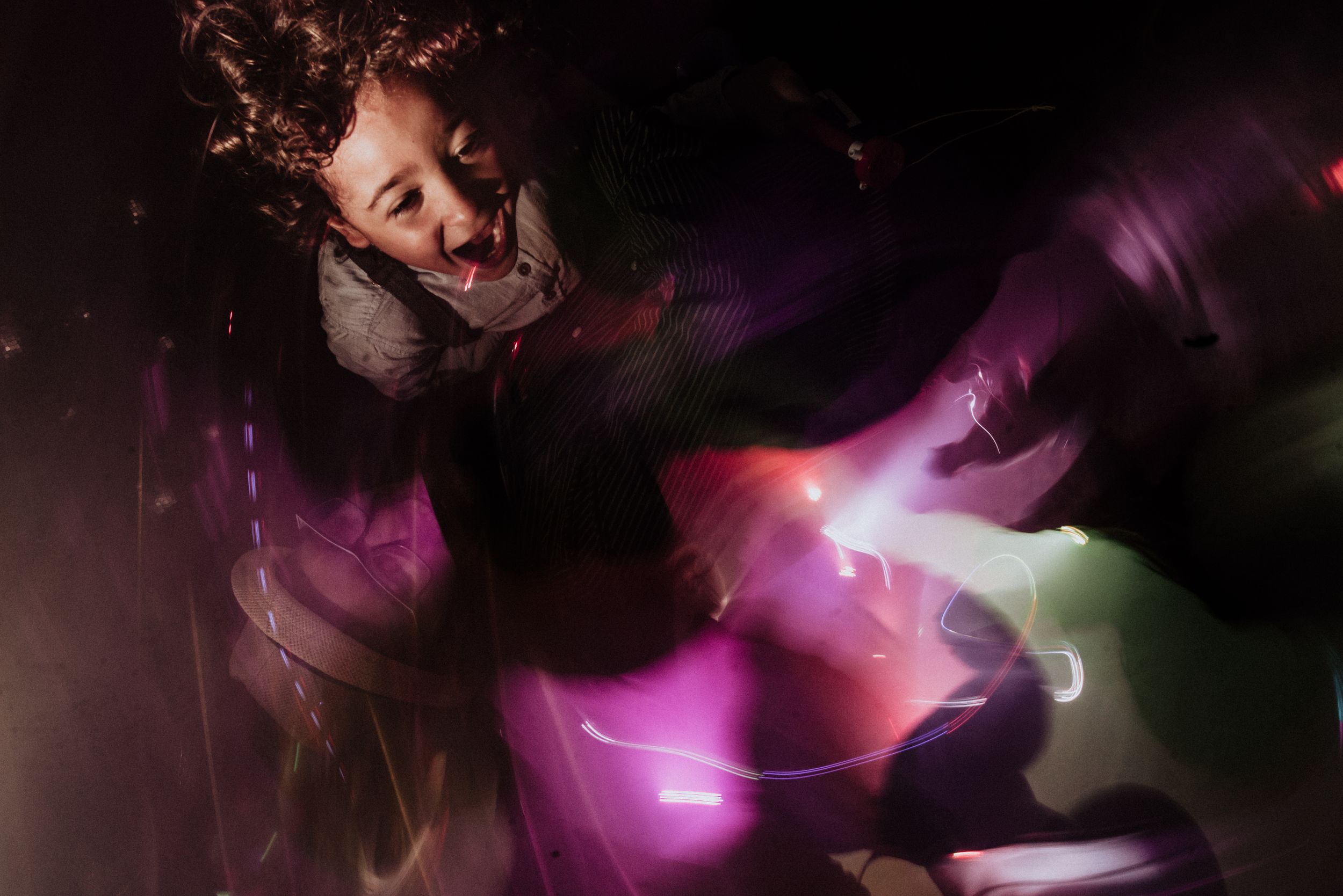 Dramatic cosplay performer with purple light streaks and glowing effects in dark setting. Fotógrafo de Bodas en Formosa