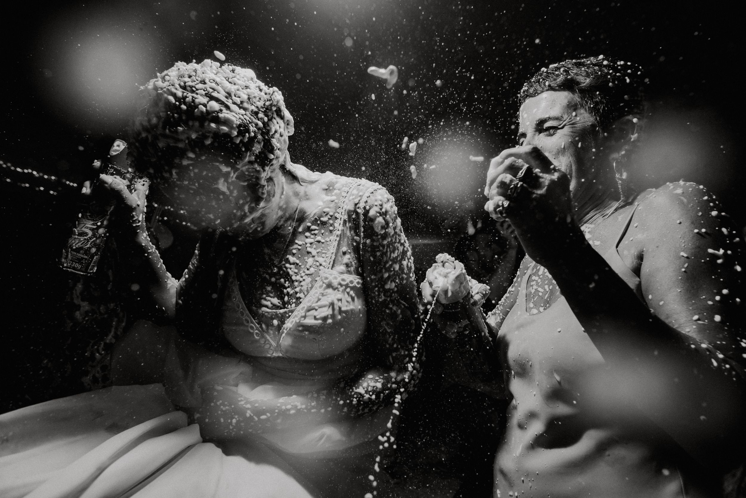 Black and white photo of bride and groom celebrating with confetti explosion at wedding. Fotógrafo de Bodas en Formosa